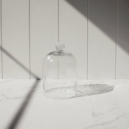 Glass Dome mini for candles pictured against a white slat wall