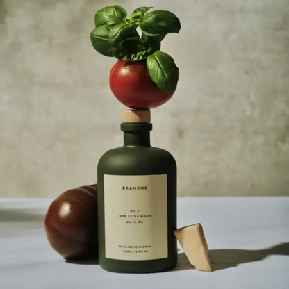 Branche Number One Olive Oil in Dark Green Matte Bottle pictured with tomatoes and basil